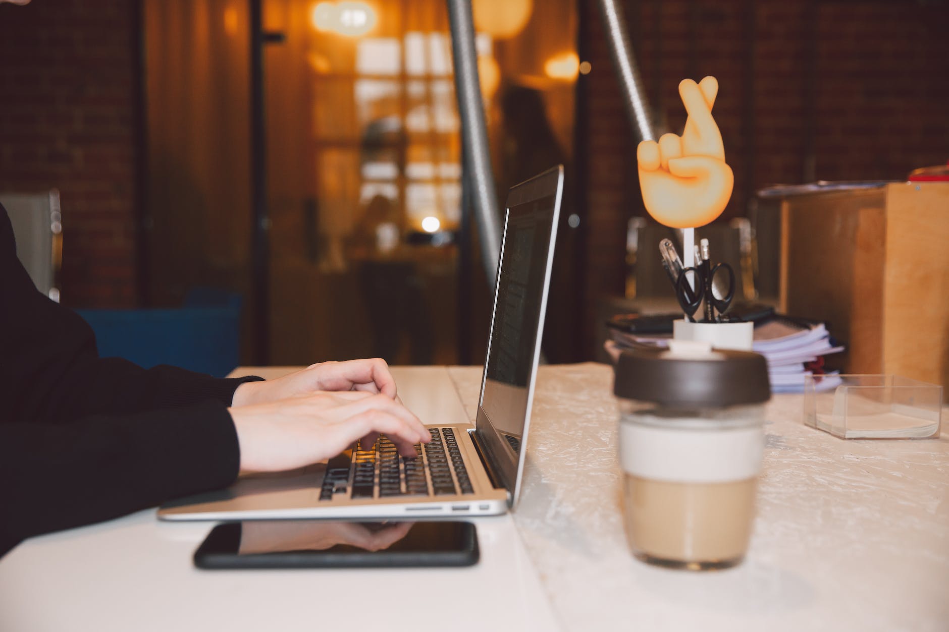person using macbook pro on white table